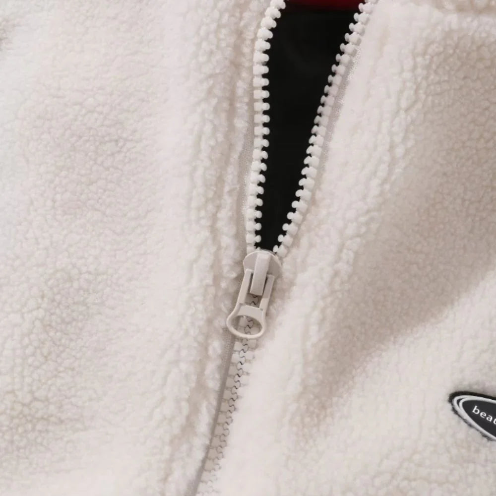 Close-up of a white fleece jacket zipper with a brand logo on a white background