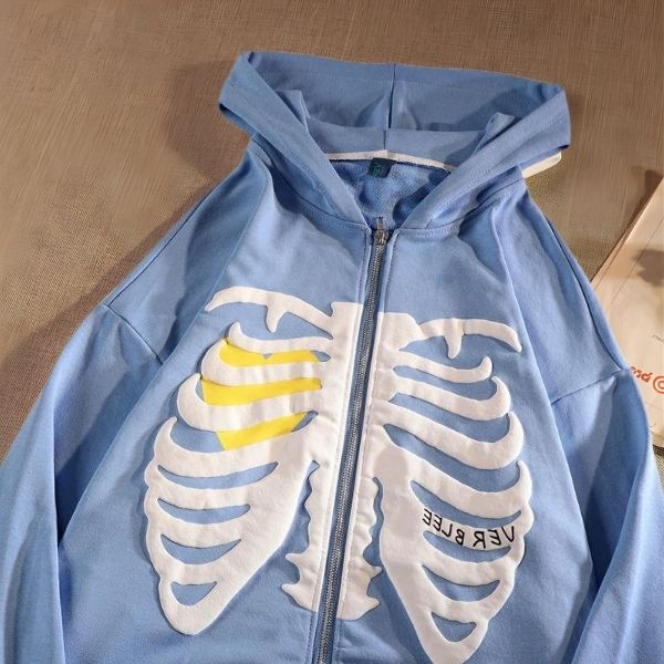 Blue hoodie with skeleton design on a wooden surface