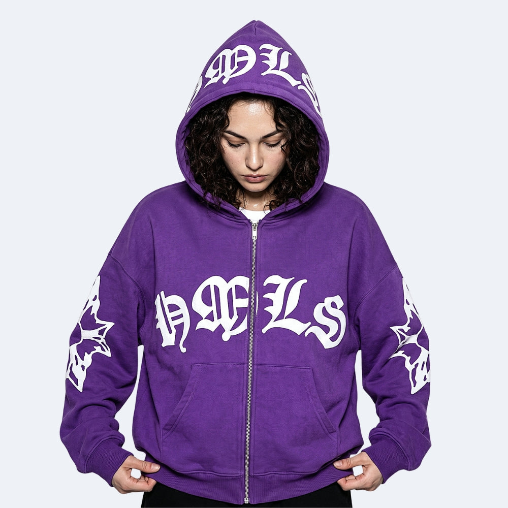 Purple. A person wearing a purple zip-up hoodie with large white Gothic-style lettering across the chest and hood, plus white sleeve graphics.