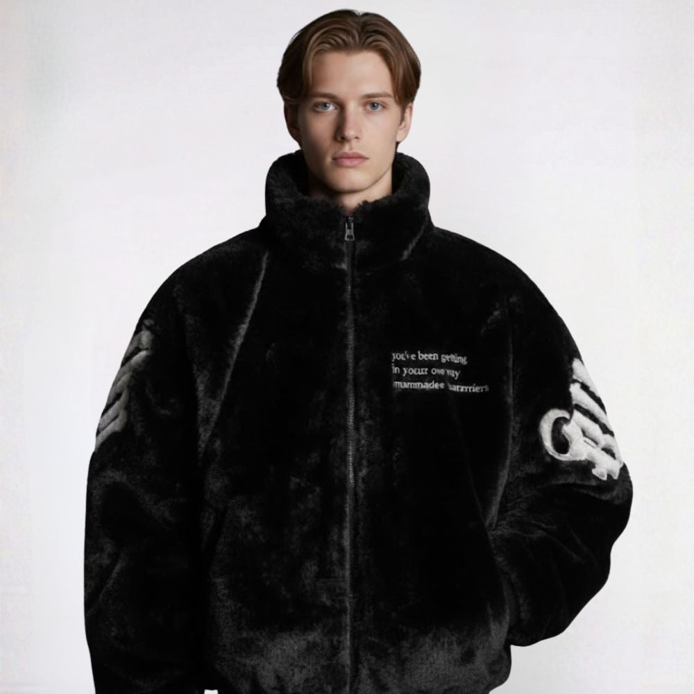 Person wearing a black textured jacket with text and branding on a white background