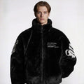 Person wearing a black textured jacket with text and branding on a white background