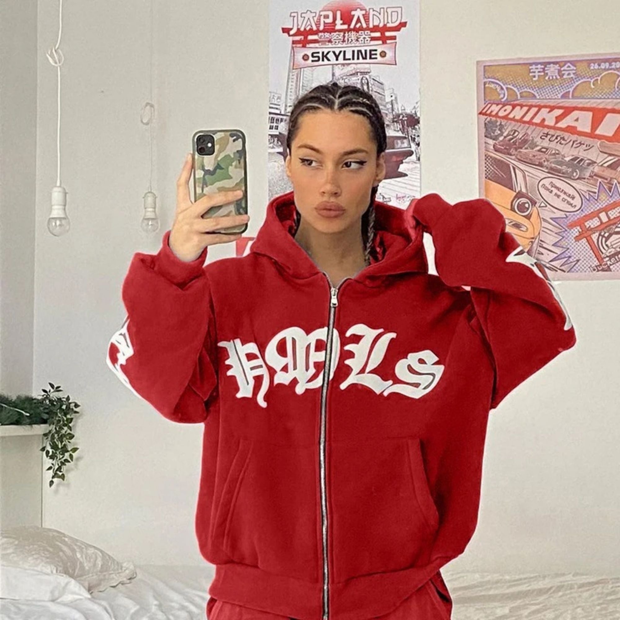 Person wearing a red hoodie with 'HOL' branding in a room with posters on the wall.