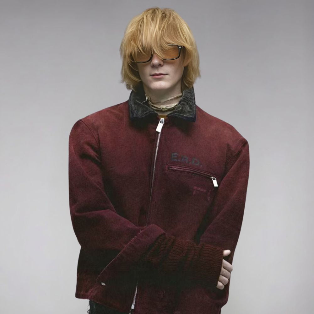 Person wearing a maroon jacket with a brand logo on a gray background