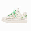 White sneaker with green accents on a white background