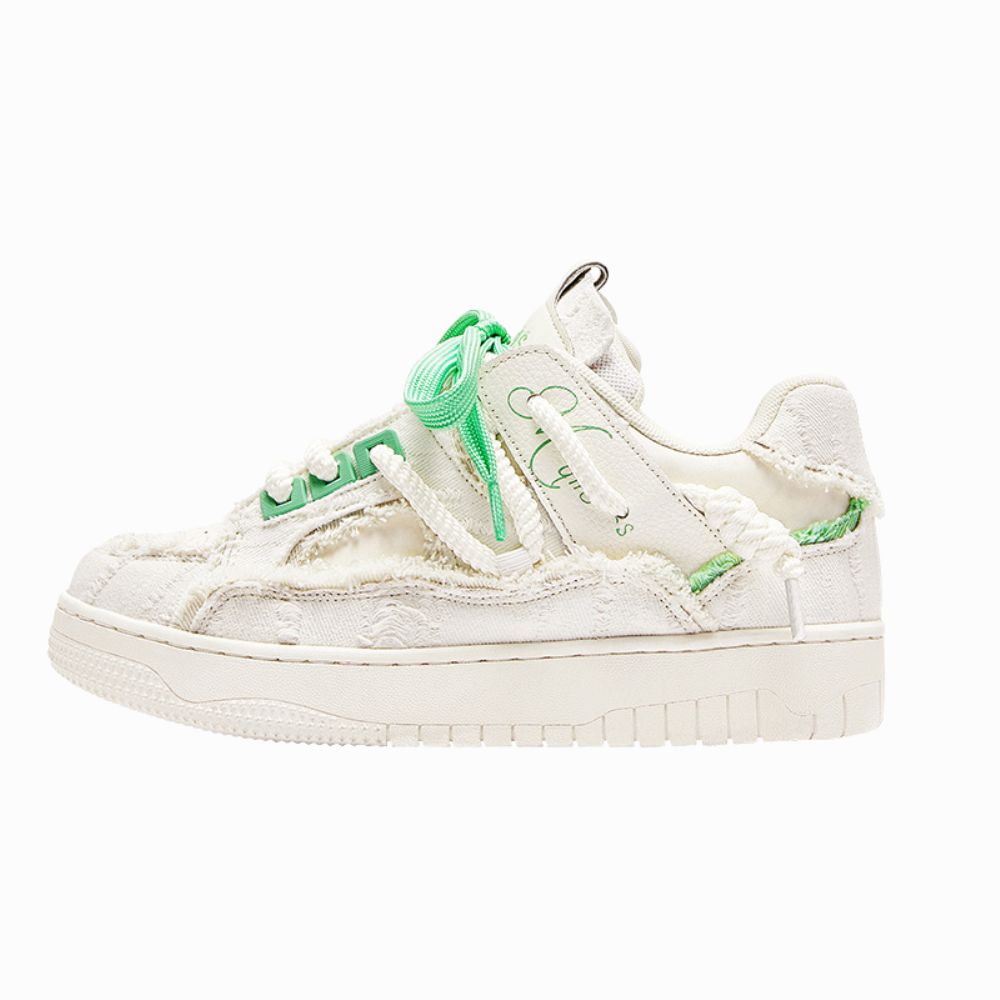 White sneaker with green accents on a white background