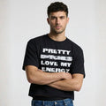 Man wearing a black t-shirt with text, standing against a plain background