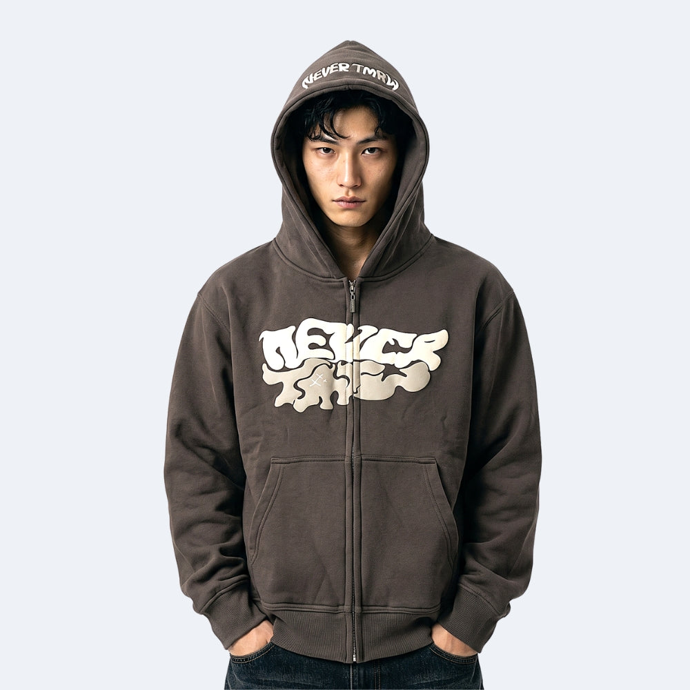 Gray. A man wearing a zip-up hoodie with a large cream-colored NEVER TRAY graphic on the front and matching text on the hood.