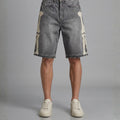 Denim shorts with patchwork design worn by a person on a gray background