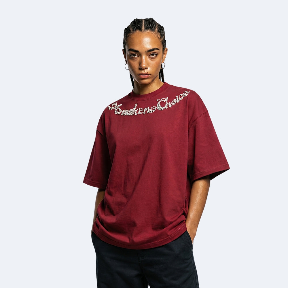 Red. A model wearing an oversized maroon t-shirt with Emotional Choice written across the chest in white script, paired with black pants.