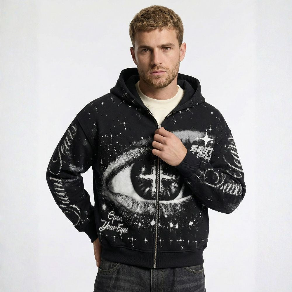 Man wearing a black hoodie with eye design and text on a white background