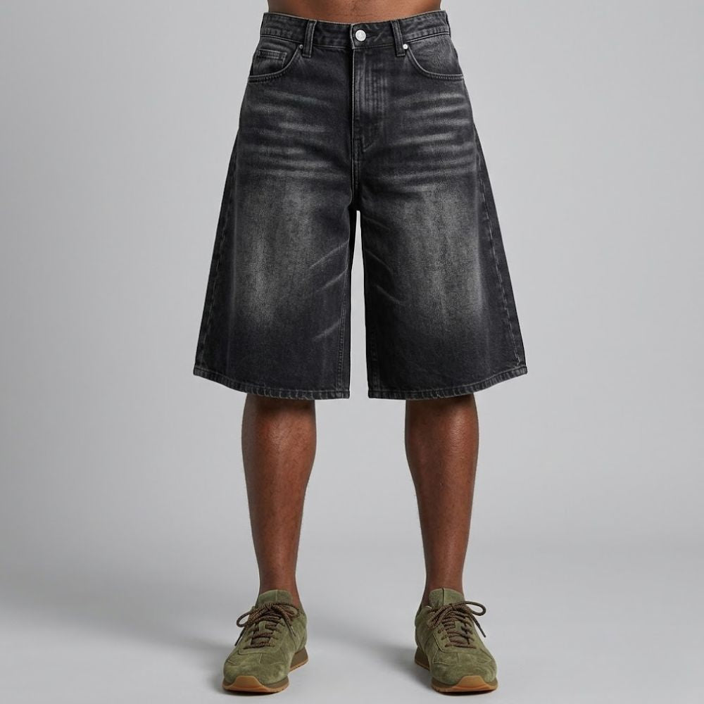 Black denim shorts worn by a person on a gray background