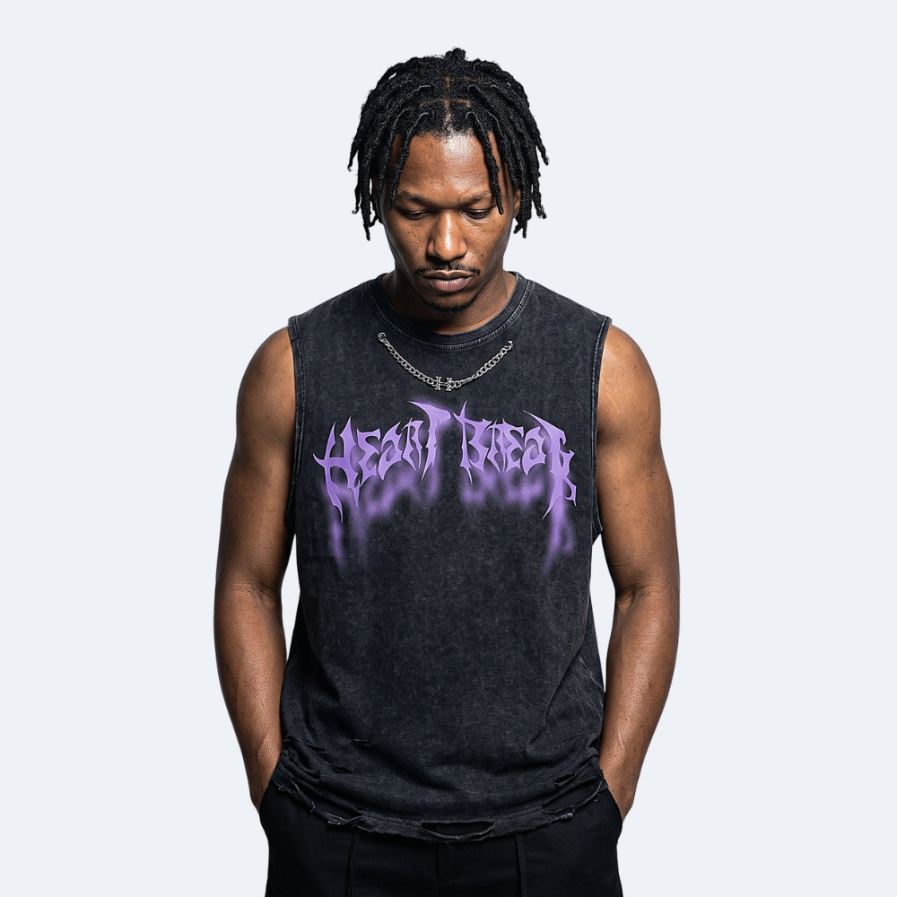 A man with black dreadlocks wearing a dark gray washed sleeveless tank top with a purple 'HEAD GEAR' logo, standing against a light gray background.