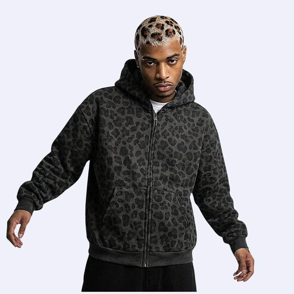 Black. KRUX Feral leopard zip hoodie in black, worn by a male model — front view, oversized fit