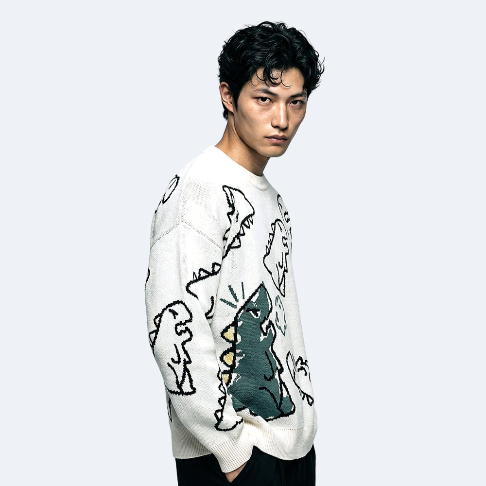 White. A man wearing a white knit sweater with a black and green abstract graphic pattern.