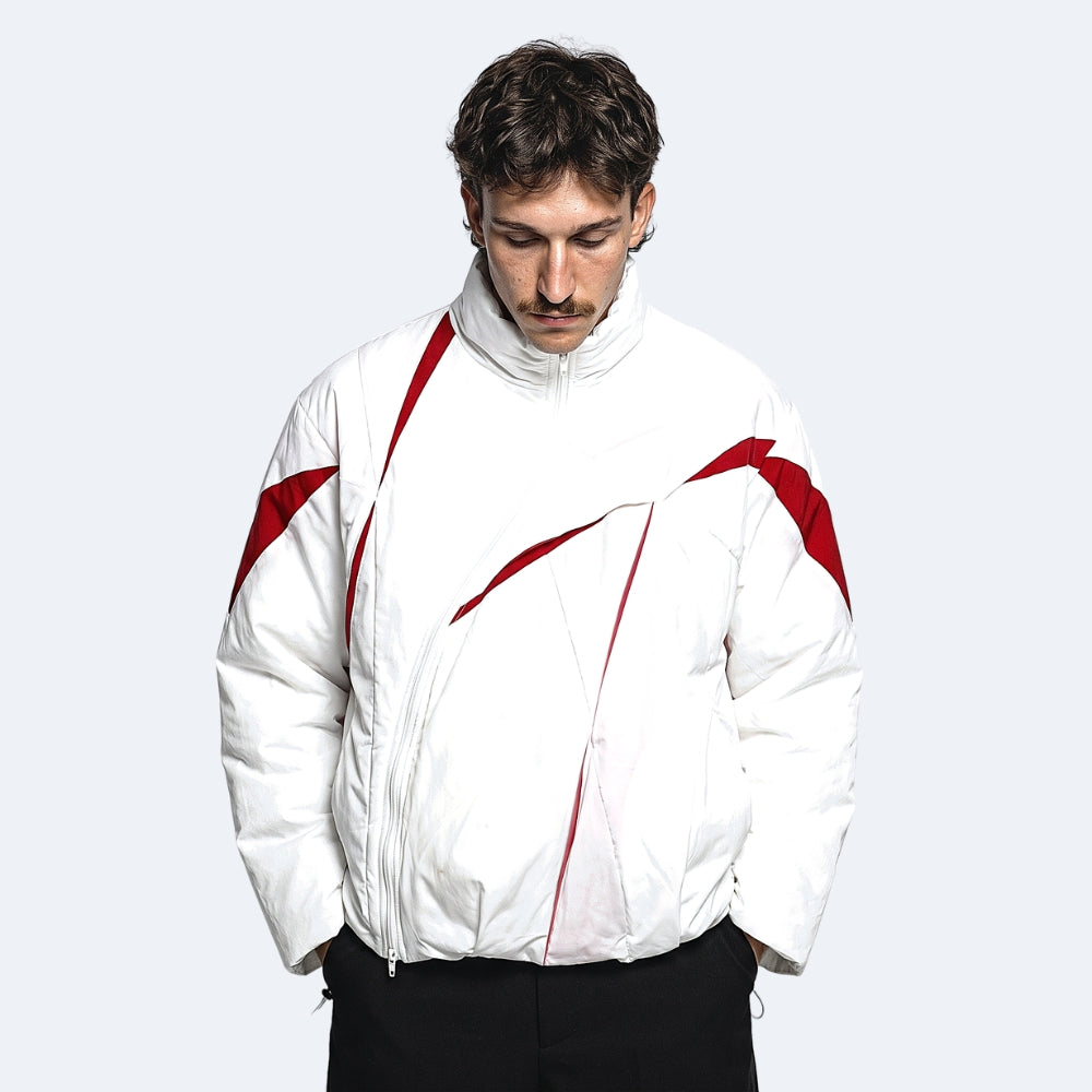 White. A man wearing a white puffer jacket with red graphic accents and black pants.