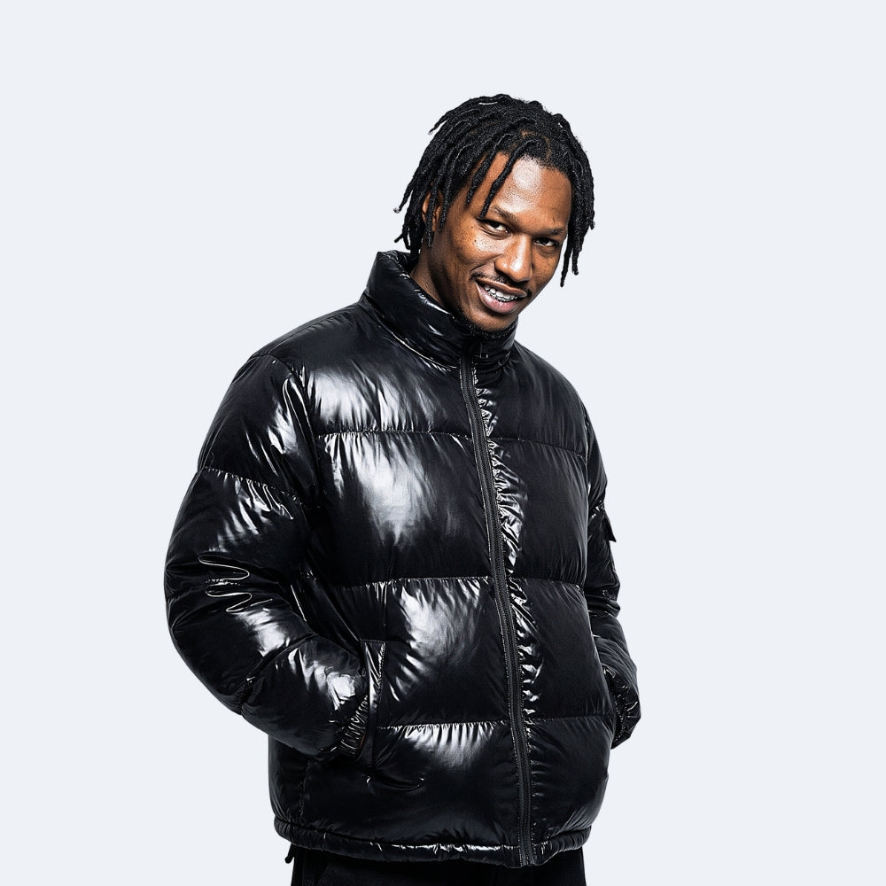 Black. A man wearing a shiny black puffer jacket.