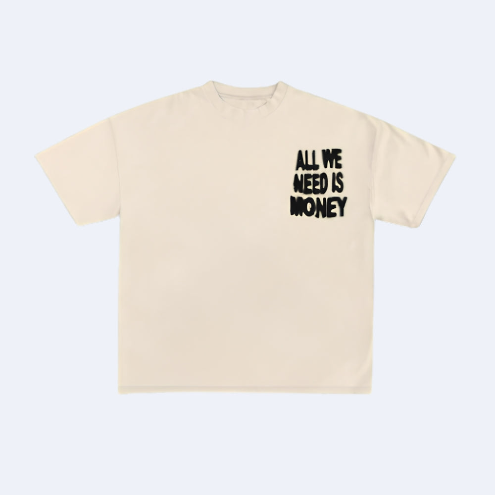 A cream-colored short-sleeve t-shirt with the text 'ALL WE NEED IS MONEY' printed in a black, distressed font on the left chest, displayed on a light gray background.