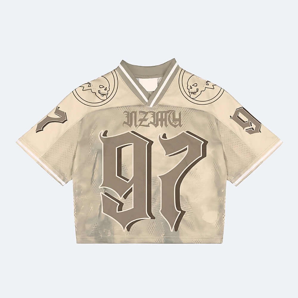 Beige. A beige and brown cropped football jersey with JAZZY and the number 97 on the front, featuring skull graphics on the shoulders.