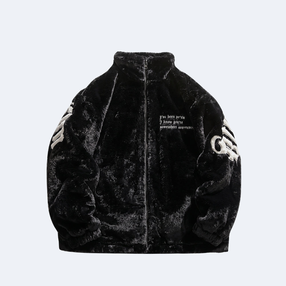 A black plush faux-fur zip-up jacket with white embroidered graphics on the sleeves and small white text on the chest, shown against a light gray background.