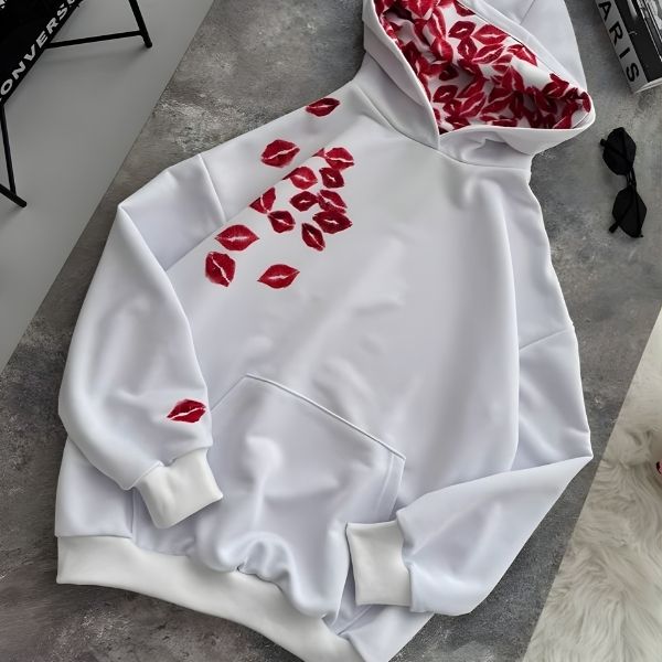 White hoodie with red lip print on a gray surface