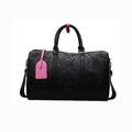 Black textured duffel bag with a pink tag on a white background