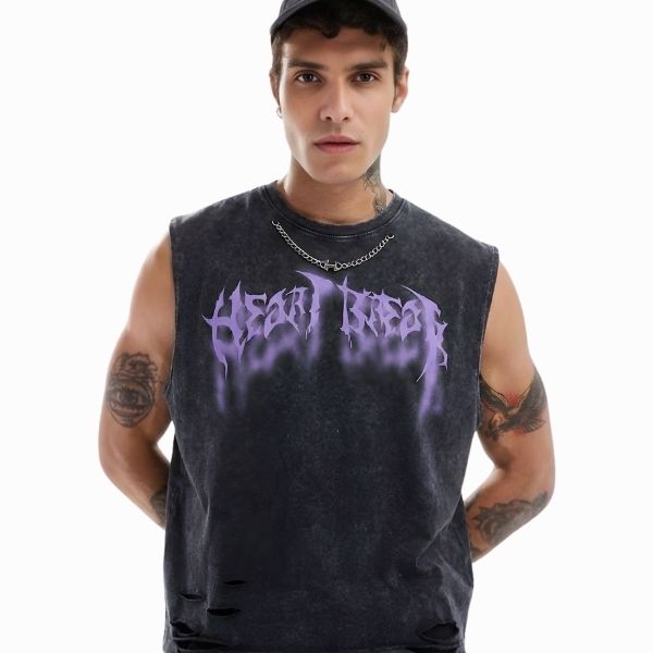 Man wearing a black sleeveless shirt with 'Heartbreak' design on a white background