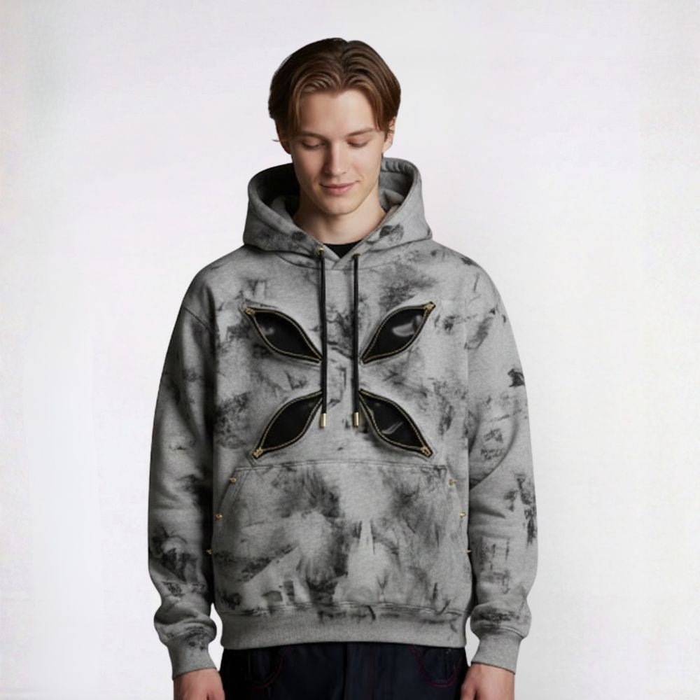 Person wearing a gray tie-dye hoodie with black leaf designs on a white background