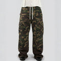 Camouflage pants worn by a person on a white background