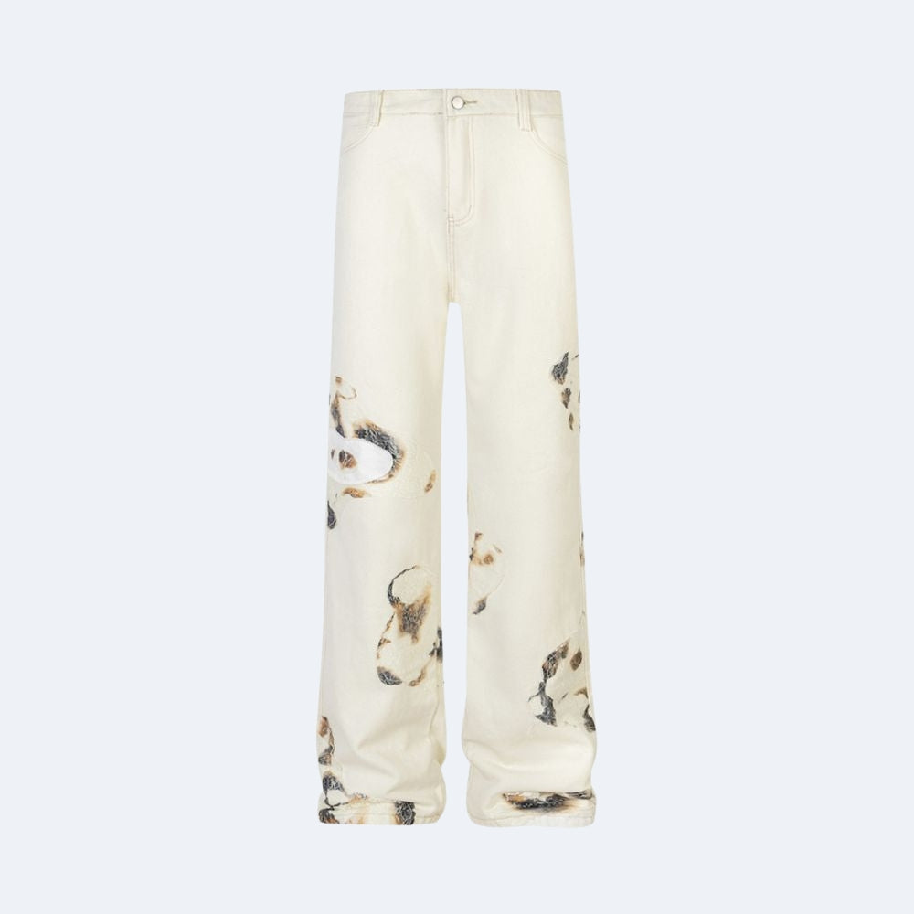 Off-white wide-leg jeans with an all-over abstract painterly print in brown, black, and beige, shown against a light gray background.
