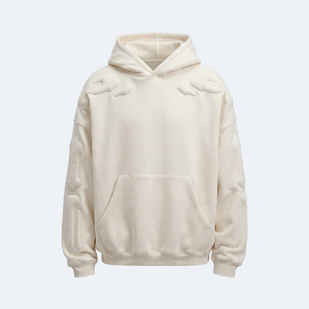 White. An oversized cream-colored hoodie with unique raised, padded details on the shoulders, sleeves, and front pocket.