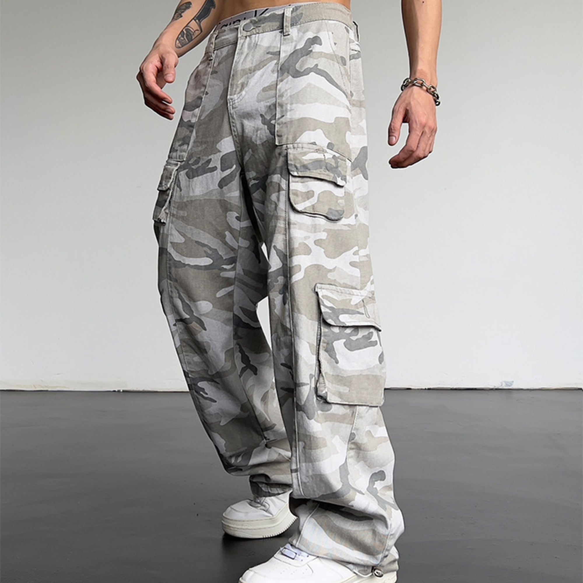 Camouflage cargo pants worn by a person on a plain background