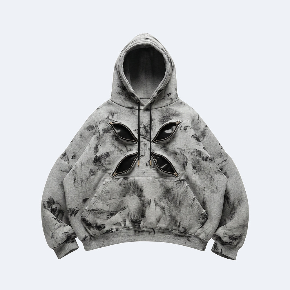 A cropped gray hoodie with a black and white abstract print, featuring a unique four-leaf clover-like cutout design on the chest with black fabric inserts.