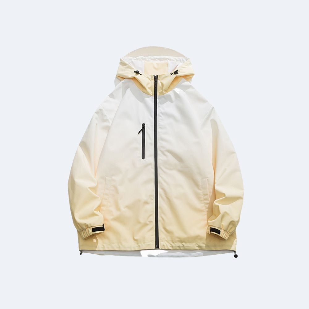 Creme. A hooded lightweight jacket in a pale yellow and off-white color-blocked design, featuring a black front zipper and a vertical black chest zipper pocket.