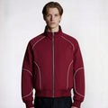 Man wearing a maroon jacket with white accents on a white background