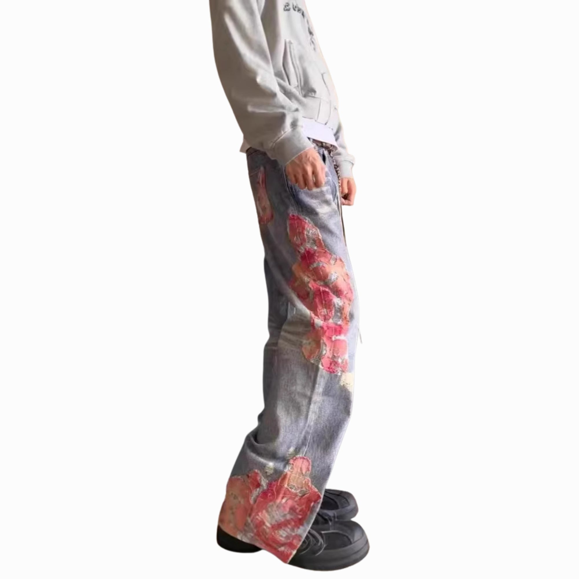 Person wearing jeans with floral designs on a white background