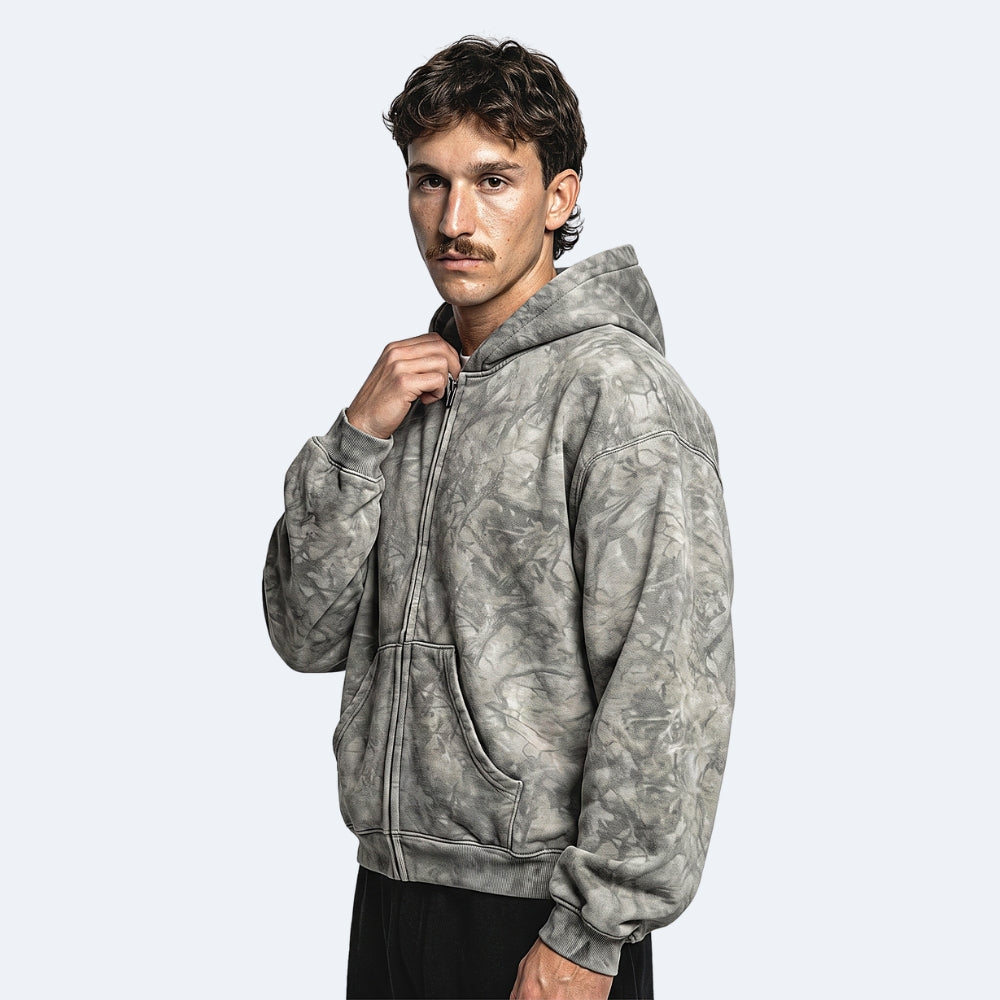 Gray. A man wearing a gray and black mottled tie-dye zip-up hoodie.
