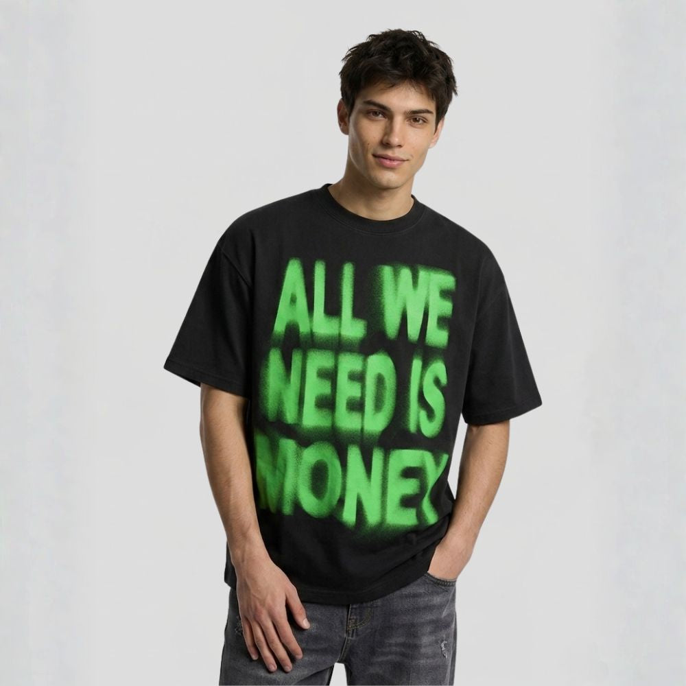 Person wearing a black t-shirt with green text 'ALL WE NEED IS MONEY' on a plain background