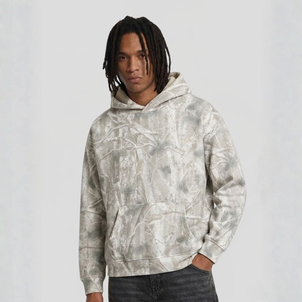 Person wearing a gray tie-dye hoodie on a white background