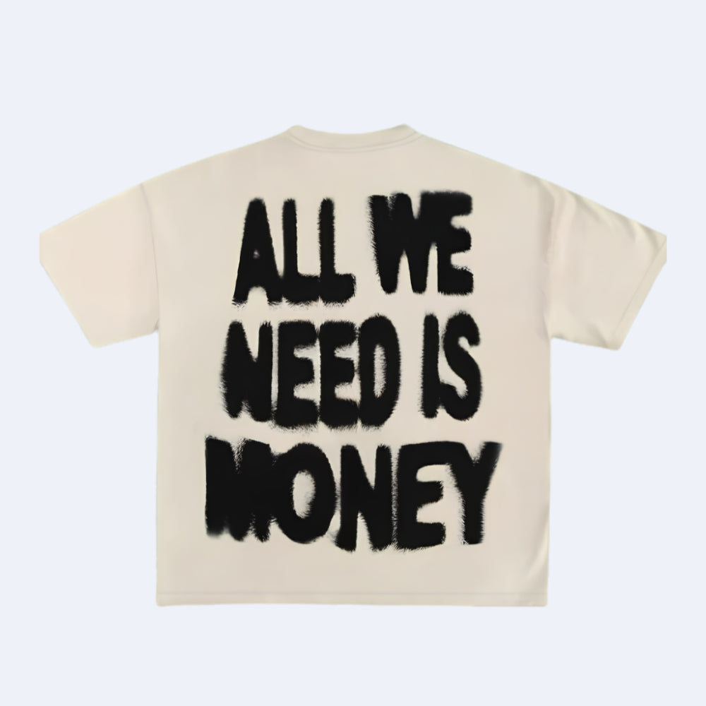 A cream-colored short-sleeve t-shirt shown from the back, featuring the phrase 'ALL WE NEED IS MONEY' printed in a bold, black, graffiti-style font.