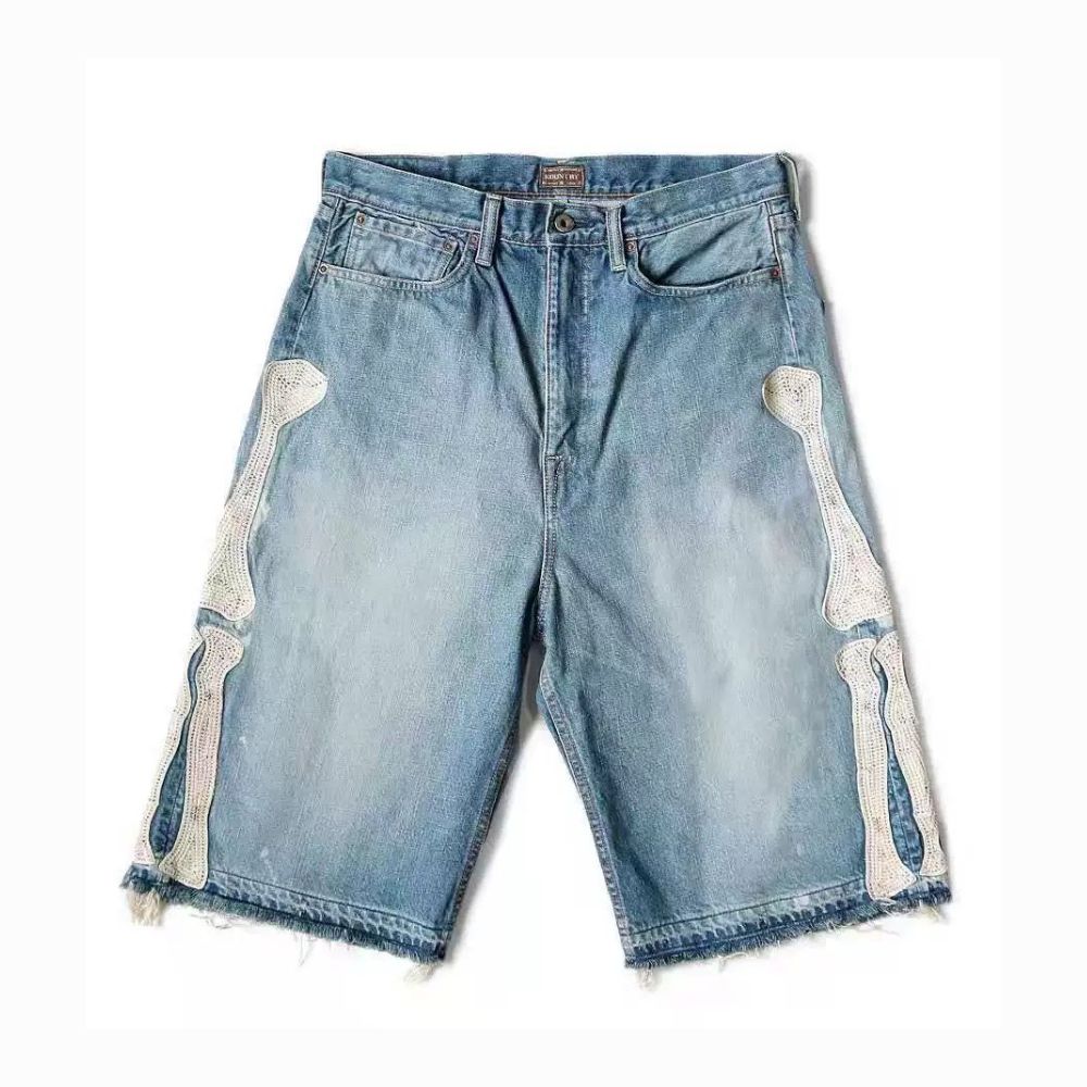 Blue denim shorts with white skeleton designs on a white background