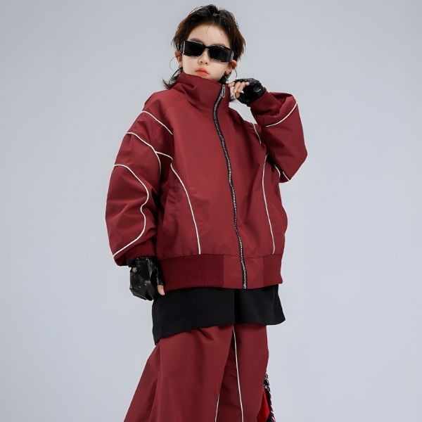 Person wearing a red jacket and pants with white accents on a gray background