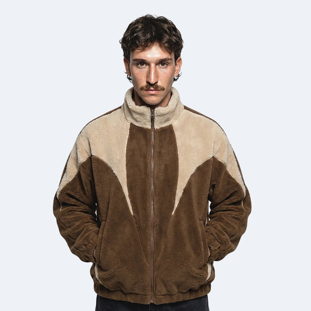 Brown. A man wearing a brown and beige color-blocked zip-up fleece jacket.