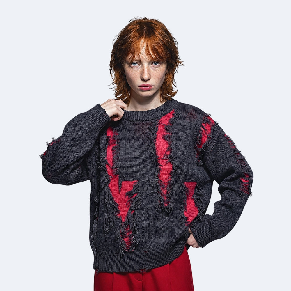 Gray Red. A model with red hair wearing a dark gray distressed knit sweater with red lining and red pants.