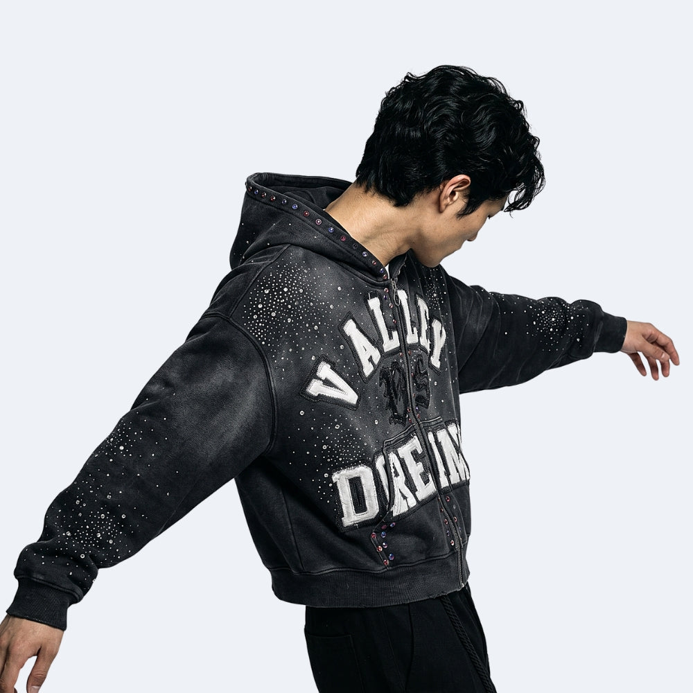 Black. A man wearing a washed black zip-up hoodie with white text printed across the chest.