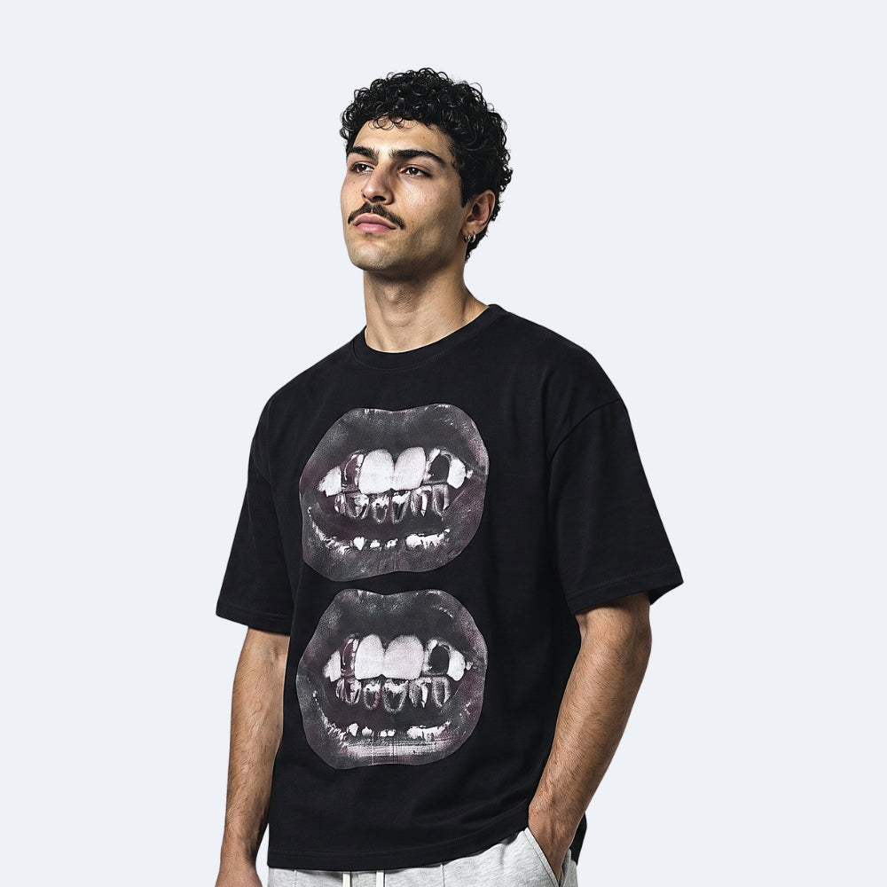 Black. A man wearing a black short-sleeve t-shirt with a graphic print of two overlapping mouths showing teeth.