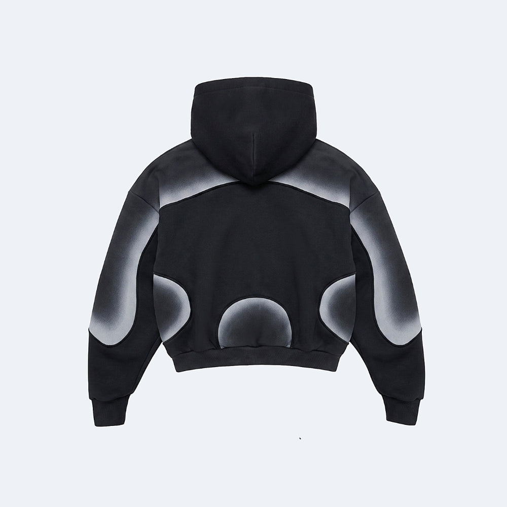 A black cropped hoodie shown from the back, featuring a gradient gray and white abstract bubble pattern on the shoulders and lower back, set against a light gray background.