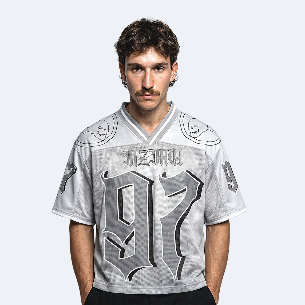 Silver. A man wearing a light gray and black graphic football jersey with the number 97 and stylized text on the front.