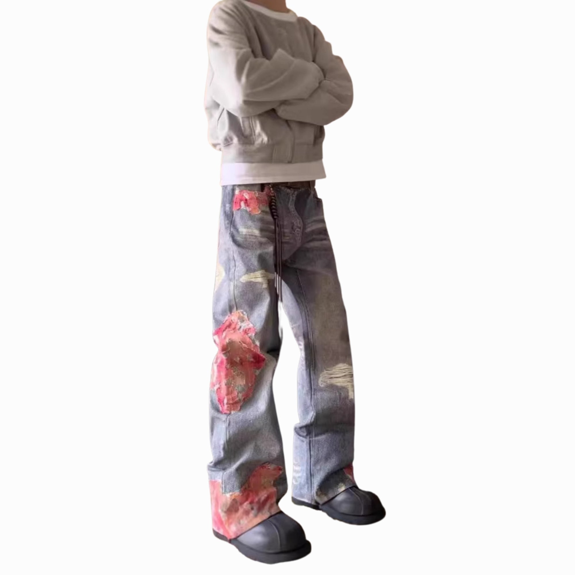 Person wearing a gray sweatshirt and floral jeans on a white background
