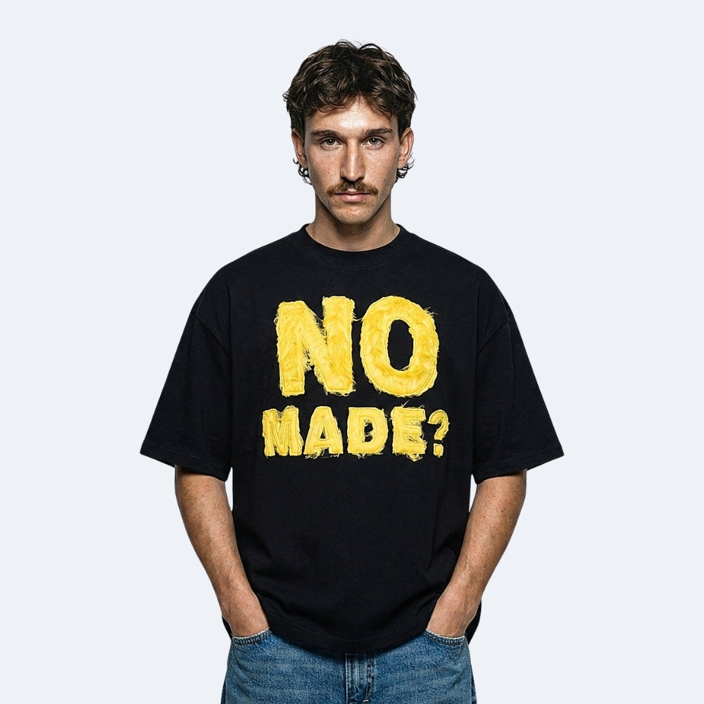 Black. A model wearing the KRUX No Made tee in black with textured lettering.