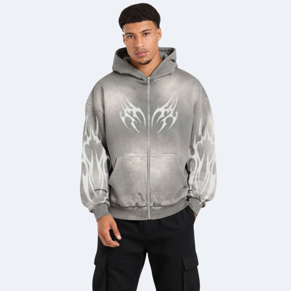 Gray. A man wearing a gray zip-up hoodie with white tribal wing and flame graphics on the front and sleeves, paired with black cargo pants.